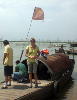 Janet Silbernagel standing on a pier in front of a boat